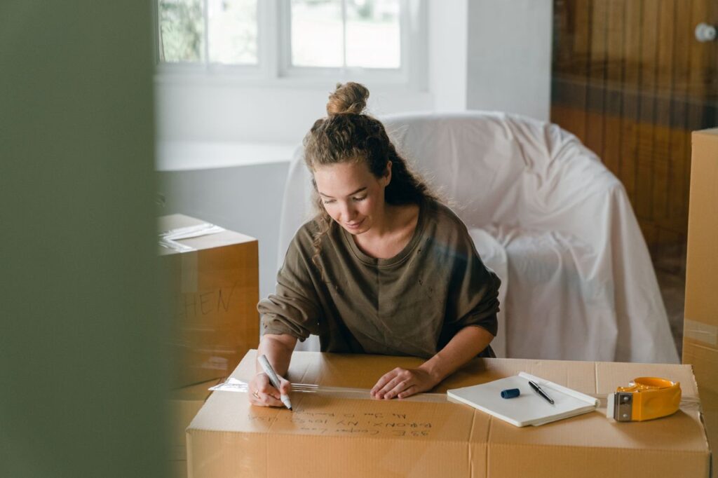 Person professionally labeling a moving box with a marker