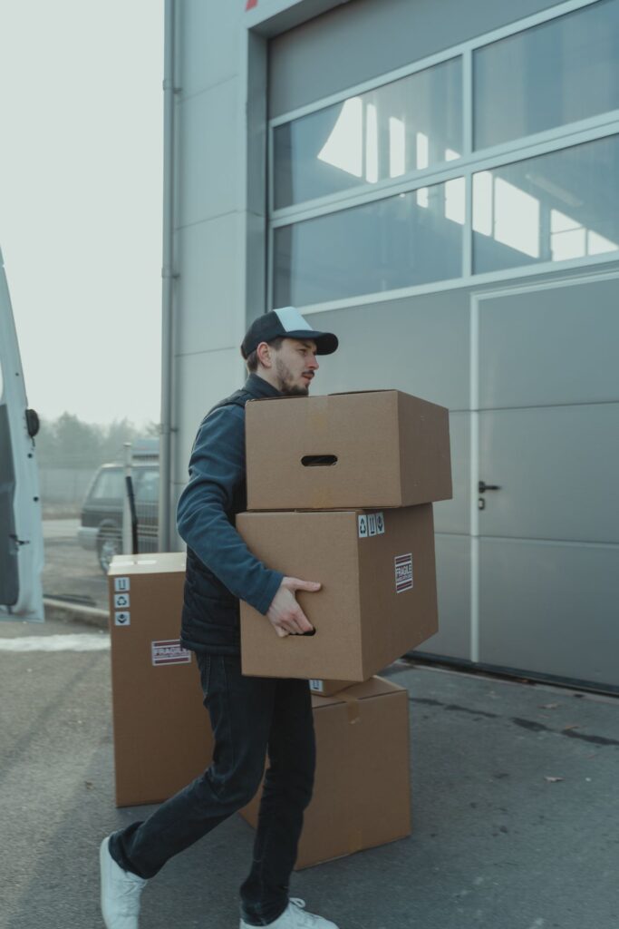 Business owner carrying a labeled office box during a move