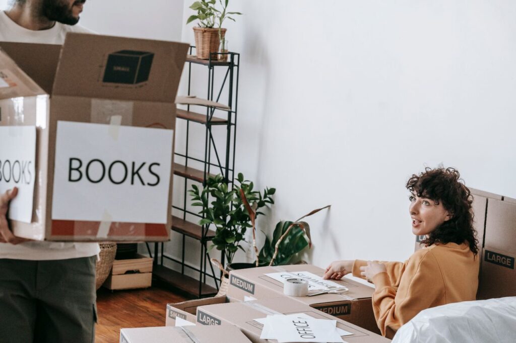 Moving box labeled "Books" being packed and sealed