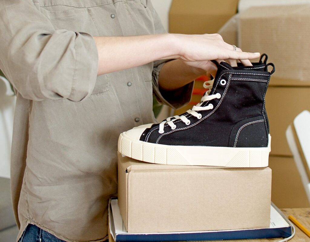Shoes being carefully packed into a moving box