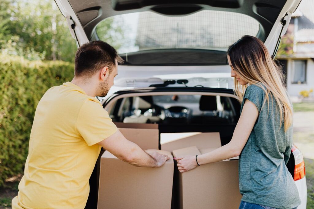 Couple moving belongings on a sunny summer day