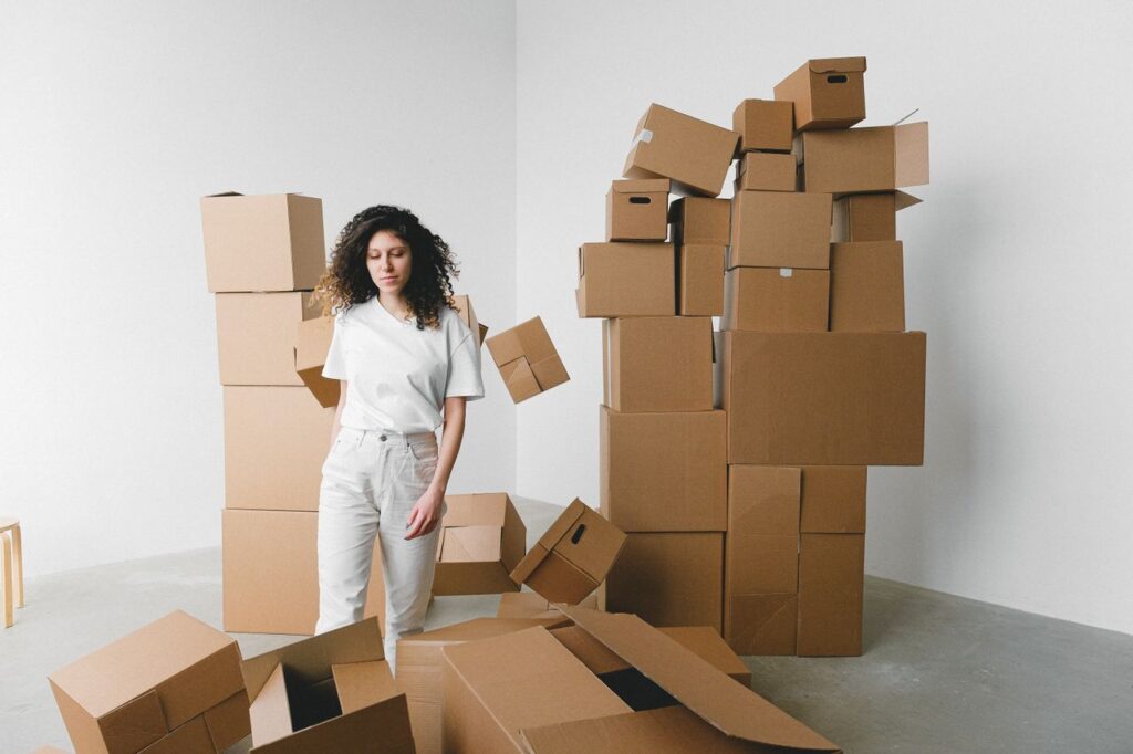 Woman surrounded by packed boxes the night before moving day
