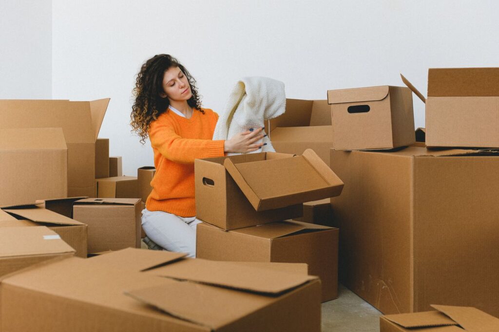 Woman quickly packing clothes into boxes ahead of moving day
